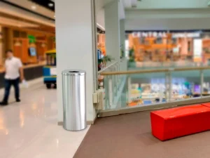 Tacho circular de acero inoxidable para reciclaje ubicado en pasadizo de centro comercial